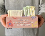 Load image into Gallery viewer, Close up photo of &quot;Your Period Box&quot; on the front it says &quot;This is a period positive bathroom&quot;. A person is holding the box up to the camera

