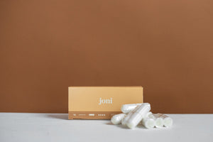 A box of joni super plus digital tampons , with 7 individual tampons resting in front of the box. 